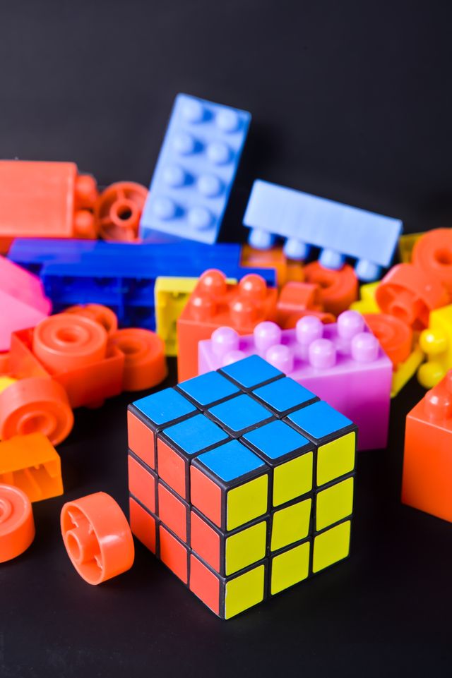 A Rubik’s cube in front of a pile of brightly coloured building bricks